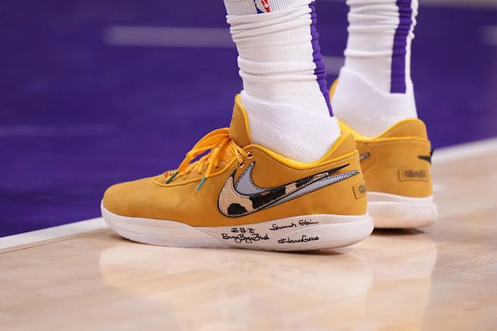 View of orange and white Nike LeBron 20 shoes.